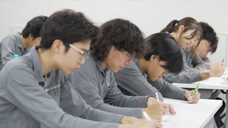 研修でノートに書き込む社員